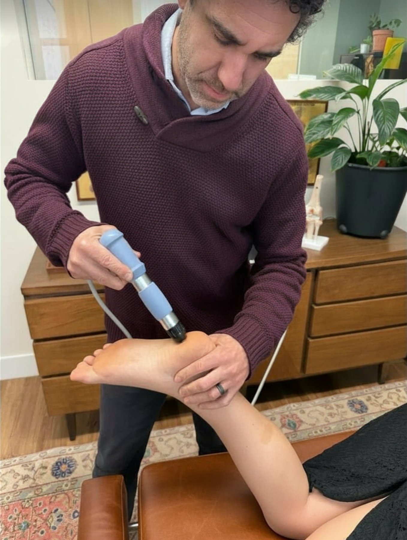 Dr. Andrew Cohen administering shockwave therapy to a patient's foot for plantar fasciitis at ProActive Chiropractic in San Francisco